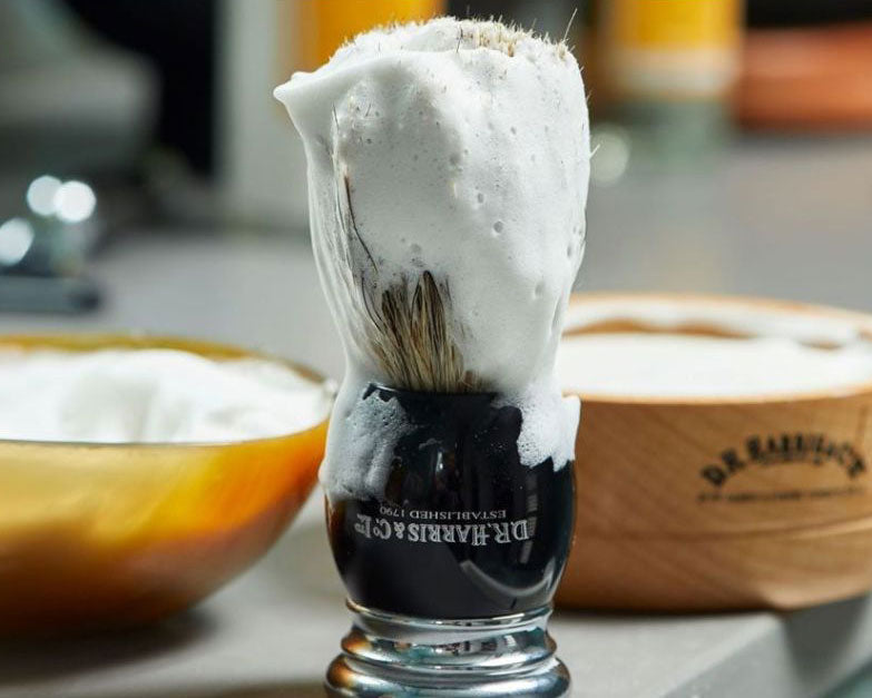 A shaving brush covered in shaving foam